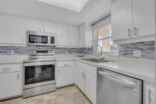 kitchen featuring white cabinets, sink, light tile patterned floors, a textured ceiling, and stainless steel appliances