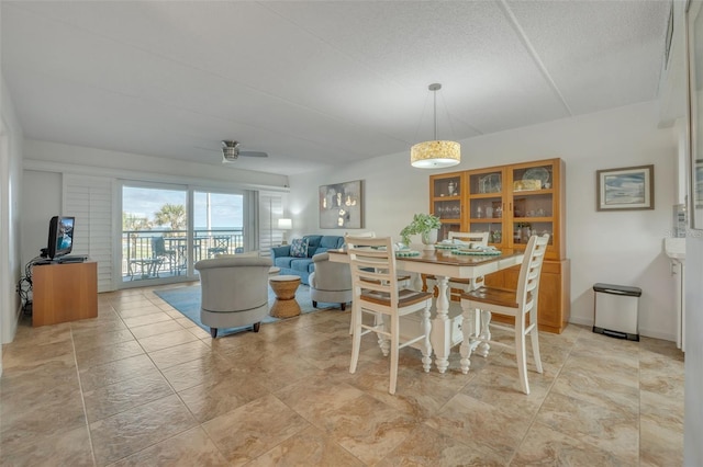 dining room with ceiling fan and a textured ceiling