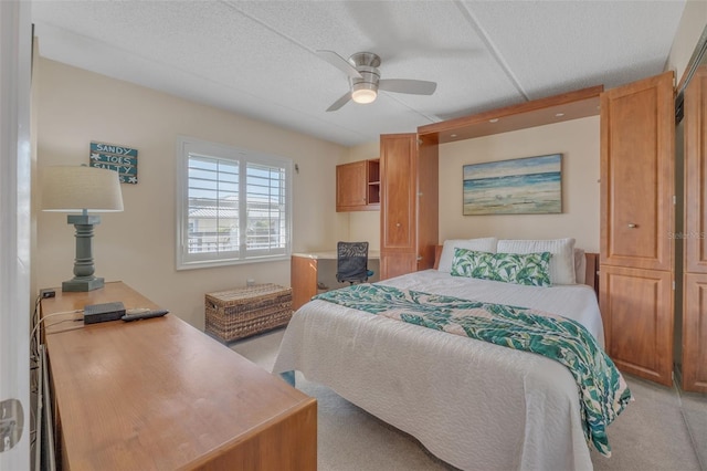 bedroom featuring a textured ceiling, light colored carpet, and ceiling fan