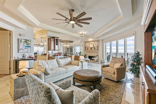 living room with a tray ceiling, ceiling fan, and crown molding