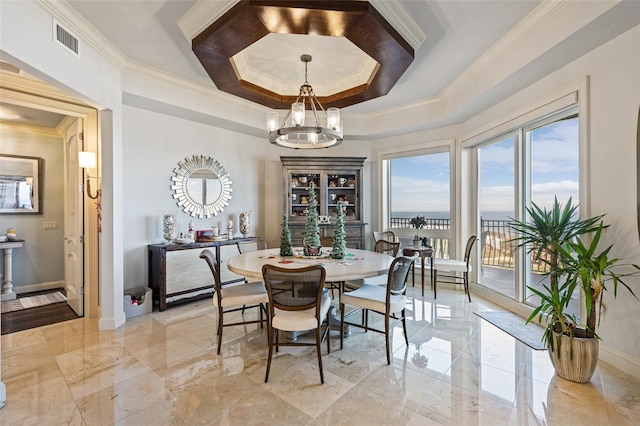 dining room featuring a raised ceiling, crown molding, and a chandelier