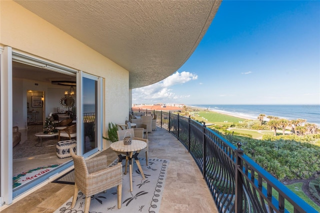 balcony featuring a water view and a beach view