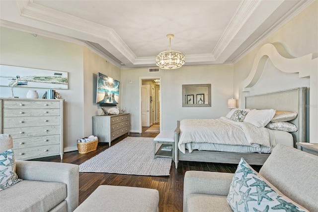 bedroom featuring a tray ceiling, crown molding, dark wood-type flooring, and a notable chandelier