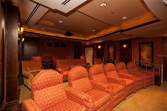 home theater featuring a raised ceiling and carpet