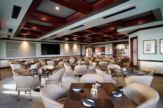 carpeted home theater room with beam ceiling, ornamental molding, and coffered ceiling