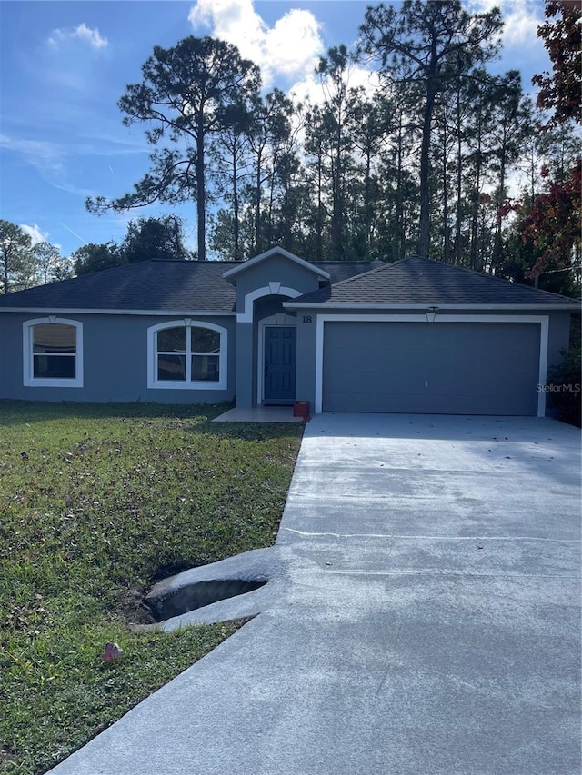 single story home featuring stucco siding, driveway, a garage, and a front yard