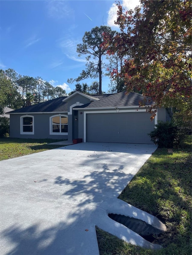 ranch-style house with stucco siding, driveway, and a garage