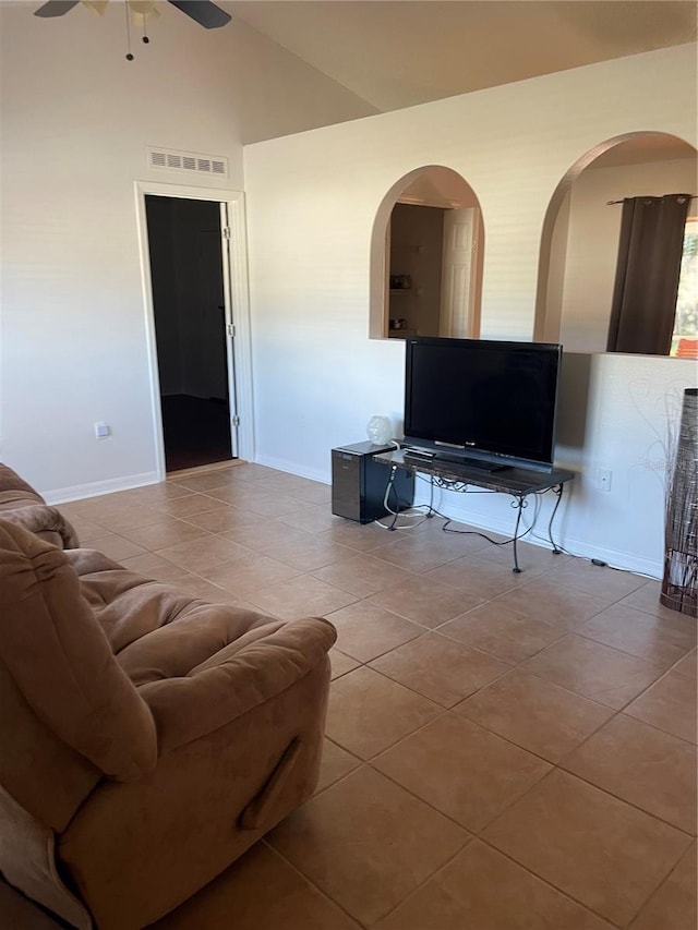 tiled living room with ceiling fan and vaulted ceiling