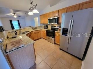 kitchen with light tile patterned floors, a peninsula, a sink, hanging light fixtures, and stainless steel appliances