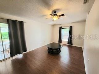 unfurnished room featuring a ceiling fan, wood finished floors, visible vents, and a textured ceiling