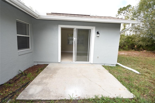 entrance to property with a patio and a lawn