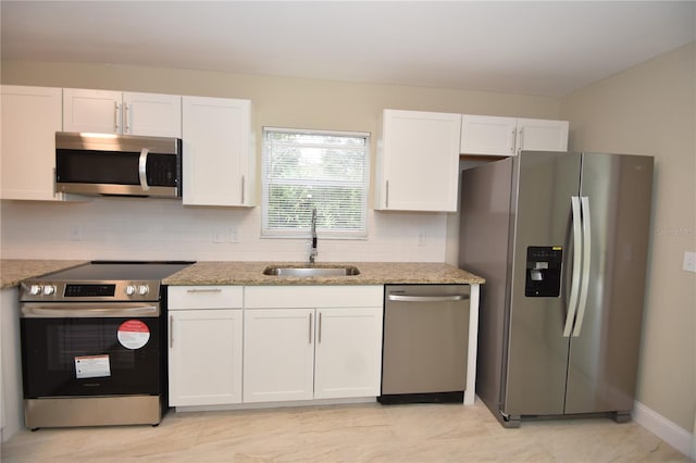 kitchen with white cabinetry, appliances with stainless steel finishes, sink, and light stone counters