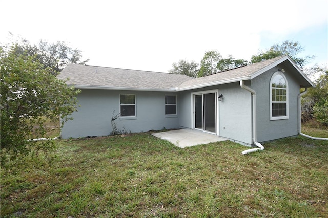 back of house with a patio area and a yard