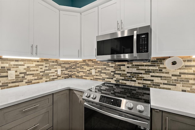 kitchen featuring white cabinets, stainless steel appliances, and tasteful backsplash