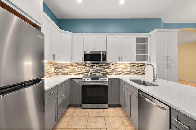 kitchen with tasteful backsplash, gray cabinets, sink, and stainless steel appliances