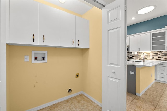 washroom featuring sink, washer hookup, cabinets, hookup for an electric dryer, and light tile patterned flooring