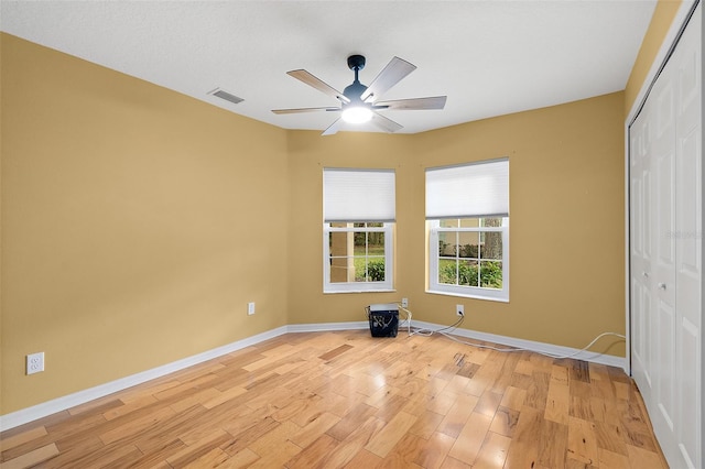 unfurnished bedroom with a closet, light hardwood / wood-style flooring, and ceiling fan