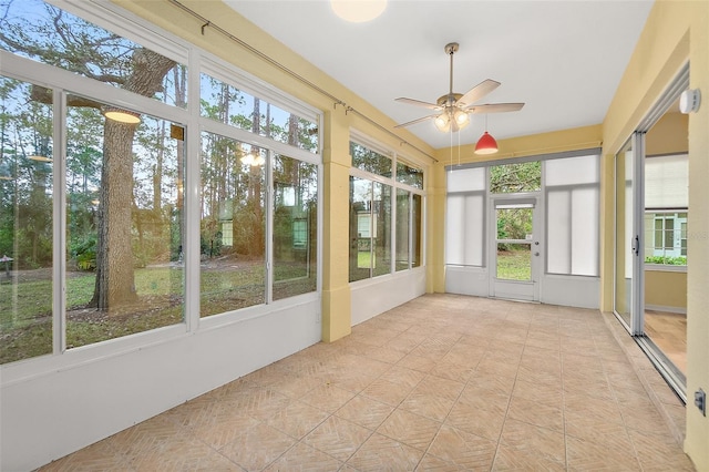 unfurnished sunroom with ceiling fan