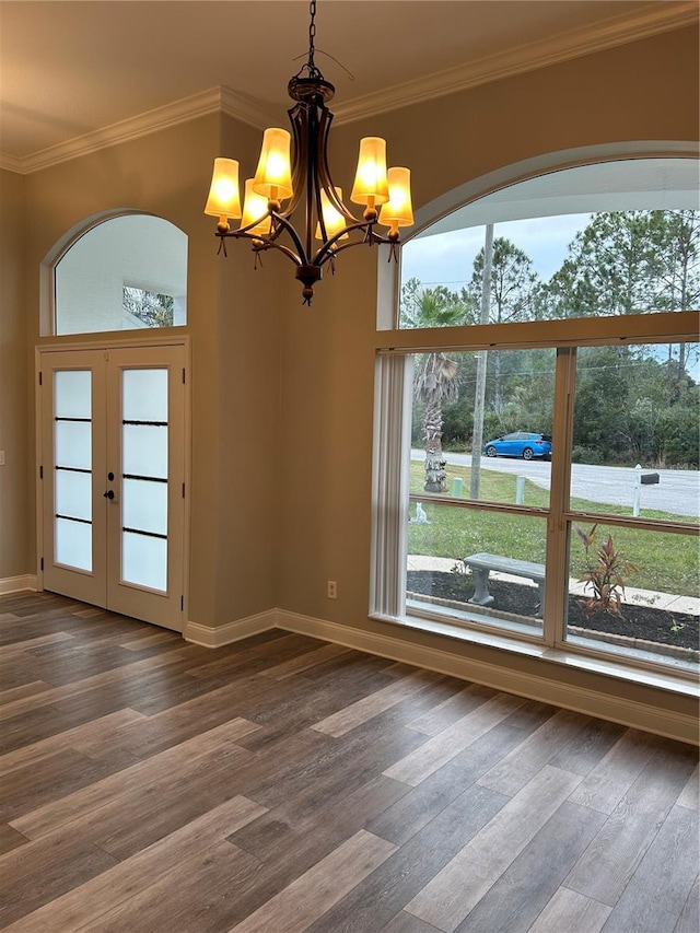 unfurnished room featuring dark hardwood / wood-style flooring, ornamental molding, french doors, and a notable chandelier