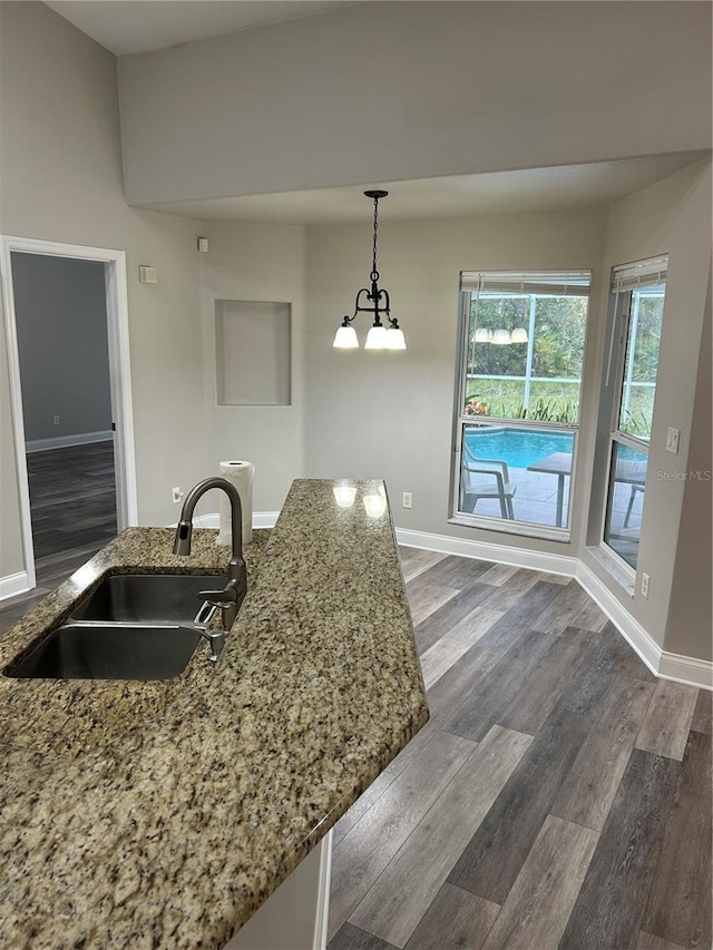 kitchen featuring dark hardwood / wood-style flooring, sink, and hanging light fixtures