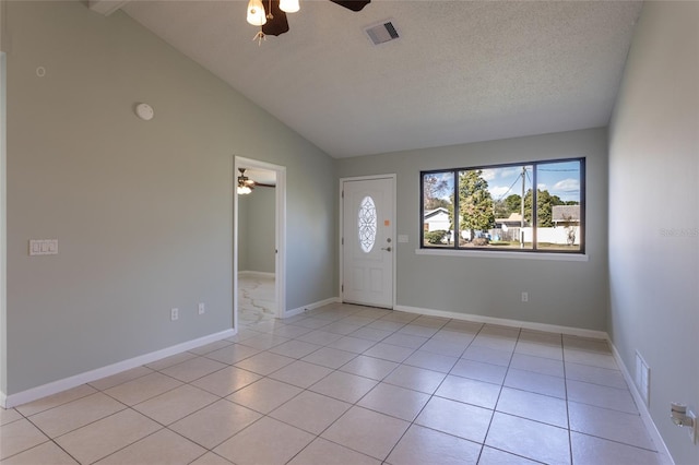 tiled entrance foyer with a textured ceiling, vaulted ceiling, and ceiling fan