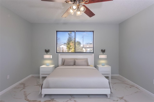 bedroom with ceiling fan and a textured ceiling