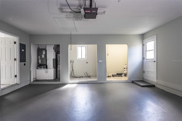 garage featuring a garage door opener, heating unit, electric panel, and water heater