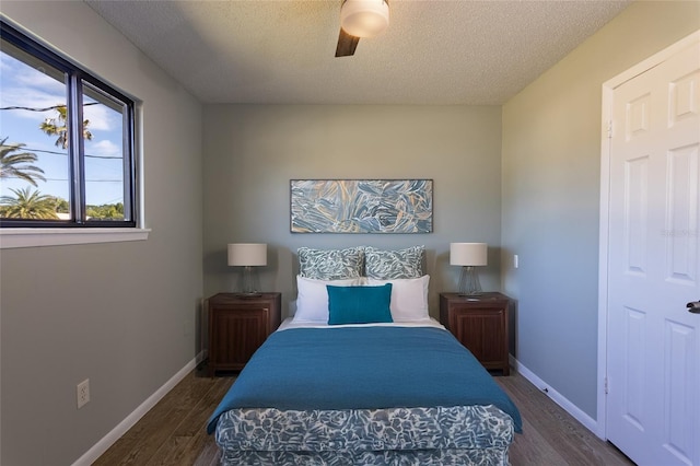 bedroom featuring ceiling fan, dark wood-type flooring, and a textured ceiling