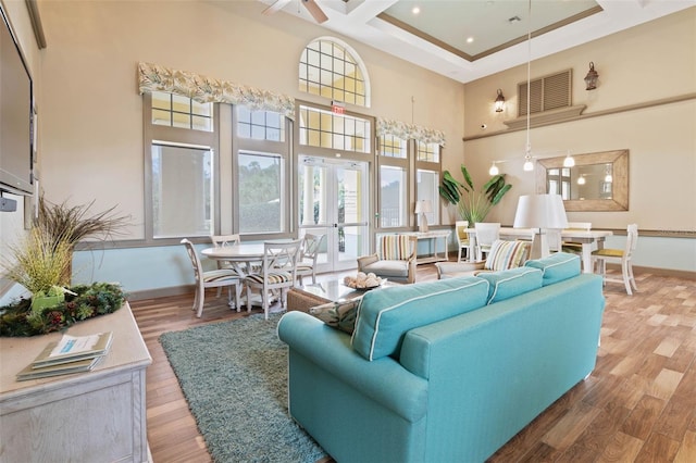 living room with french doors, coffered ceiling, a towering ceiling, hardwood / wood-style flooring, and ceiling fan