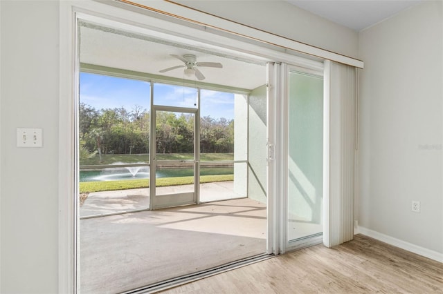 doorway featuring a water view, ceiling fan, and light wood-type flooring