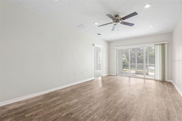 unfurnished room with hardwood / wood-style flooring, ceiling fan, and a textured ceiling