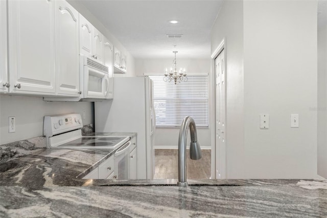 kitchen featuring white cabinetry, a chandelier, white appliances, and decorative light fixtures