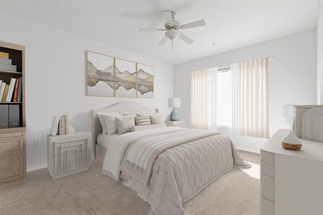 bedroom featuring ceiling fan, light carpet, and a textured ceiling