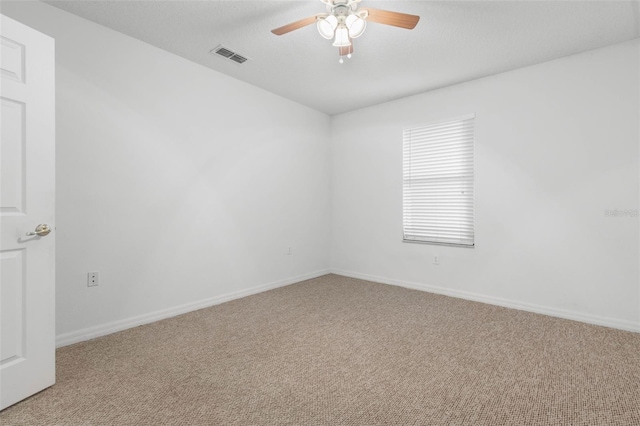 spare room featuring ceiling fan, carpet floors, and a textured ceiling