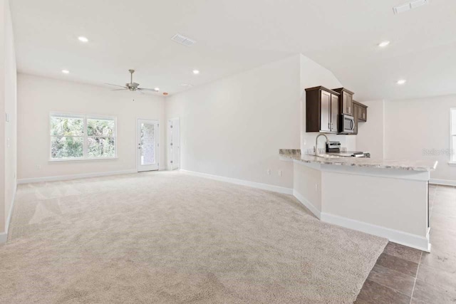 unfurnished living room featuring ceiling fan and carpet flooring