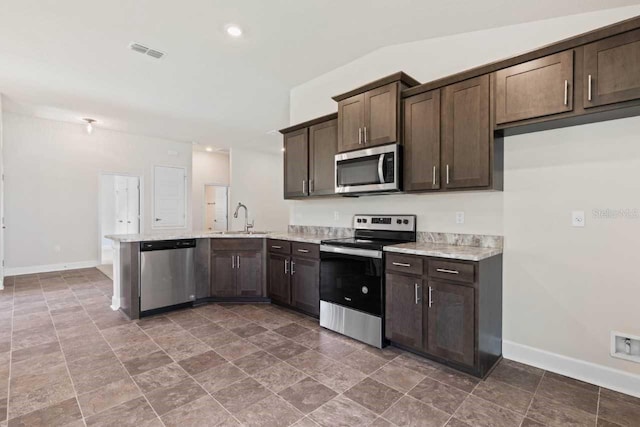 kitchen with dark brown cabinetry, appliances with stainless steel finishes, kitchen peninsula, and sink