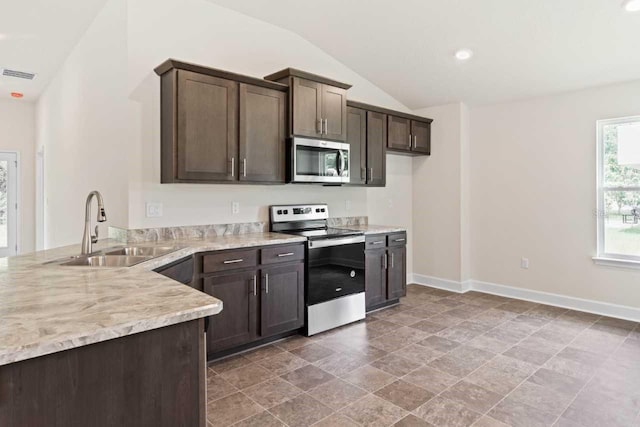 kitchen featuring sink, dark brown cabinets, vaulted ceiling, and appliances with stainless steel finishes