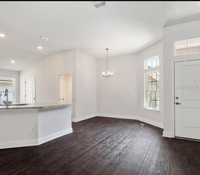 entryway featuring dark wood-type flooring, vaulted ceiling, a chandelier, and sink