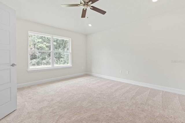 spare room with ceiling fan and light carpet