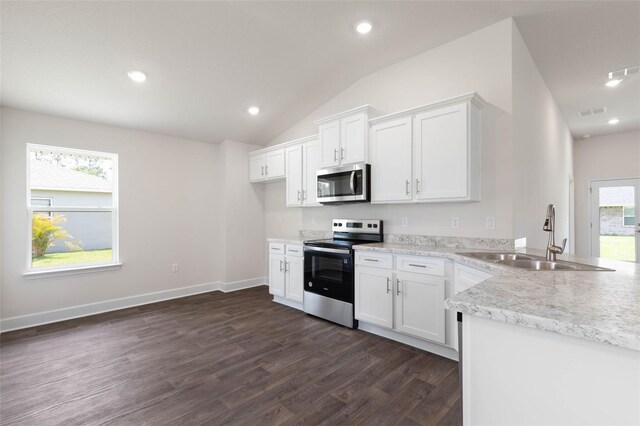 10 Zinc Pl, Palm Coast, FL 32164 - kitchen with appliances with stainless steel finishes, a sink, dark wood-style floors, vaulted ceiling, and white cabinets
