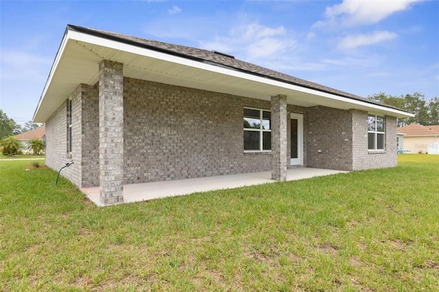 10 Zinc Pl, Palm Coast, FL 32164 - rear view of house featuring a yard, brick siding, and a patio