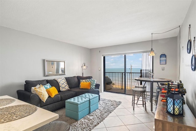 tiled living room with a water view and a textured ceiling