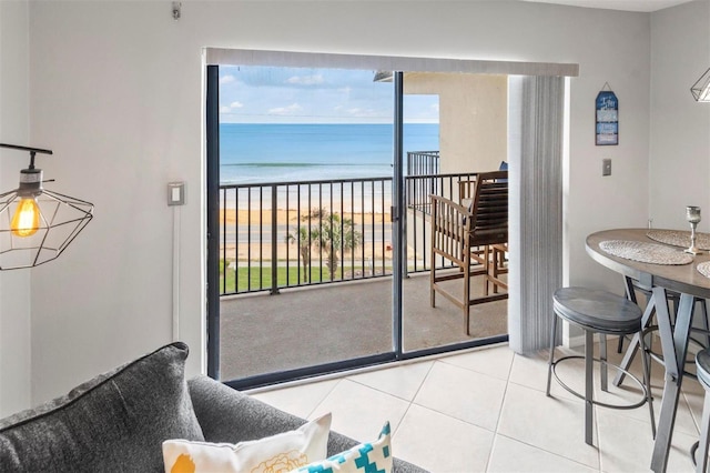 tiled living room featuring a view of the beach and a water view