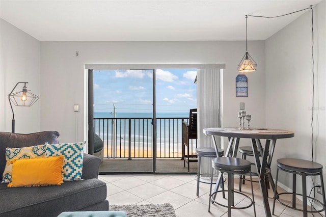 dining space with a water view and light tile patterned flooring