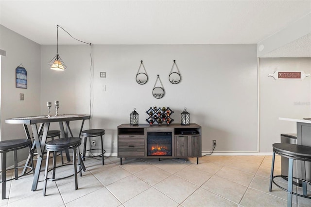 bar with a fireplace, light tile patterned floors, and decorative light fixtures