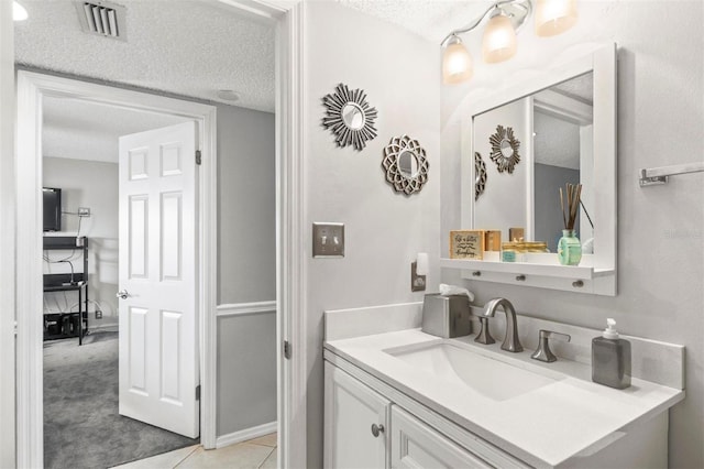 bathroom with vanity, a textured ceiling, and tile patterned flooring