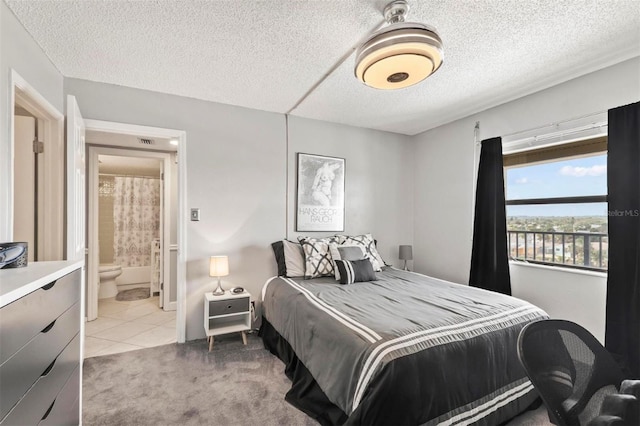 tiled bedroom featuring a textured ceiling and ensuite bath