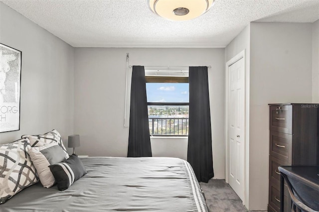 carpeted bedroom with a textured ceiling and a closet