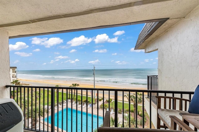 balcony featuring a water view and a beach view