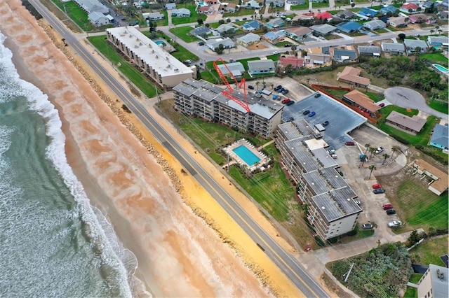 birds eye view of property with a water view and a view of the beach